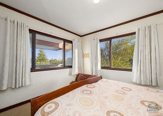 Corner bedroom with queen bed and garden views