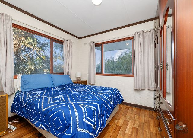 Bedroom with queen bed and wardrobe mirror
