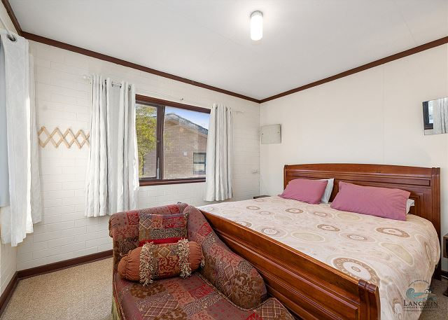 Bedroom with queen bed and armchair