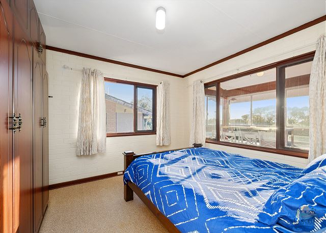 Bedroom with blue bed and built-in wardrobe