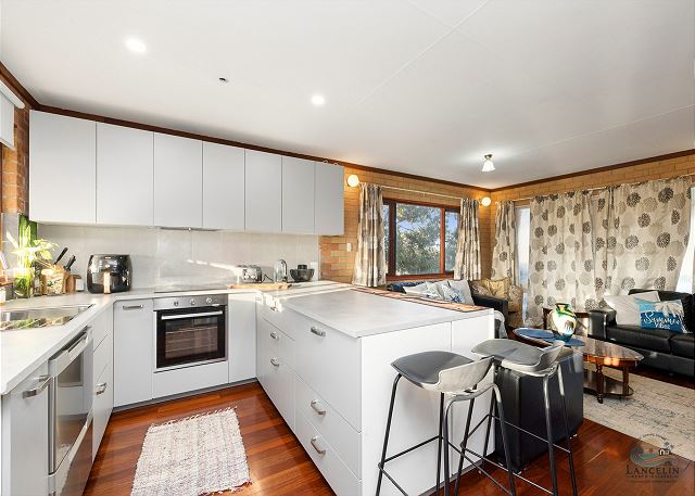 Open kitchen with island bench and bar stools